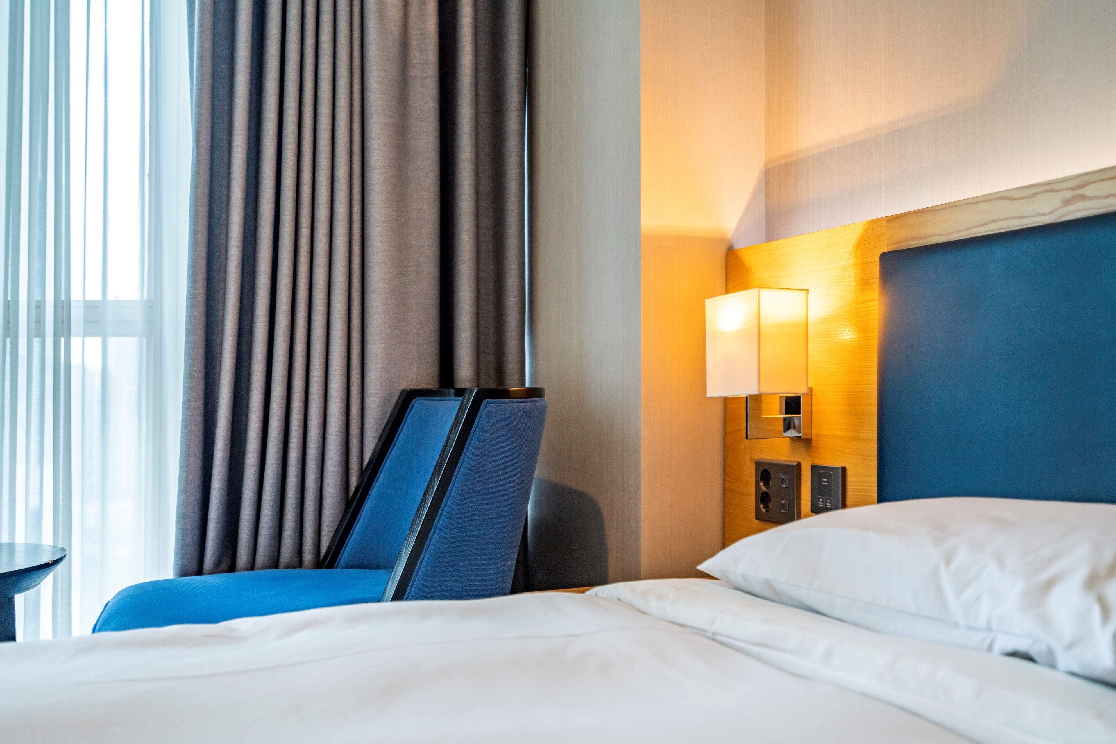 Habitación de hotel con cama, escritorio y lámpara.