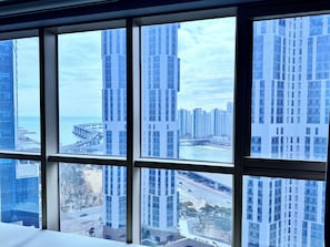 Vista a través de una ventana que muestra edificios altos, un puente y una masa de agua.
