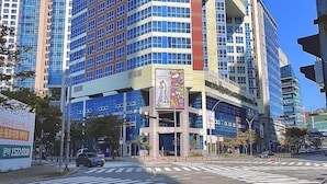 A multi-story hotel with a prominent corner entrance, large windows, and a visible sign advertising wedding services. - Centum Business Hotel (Busan)