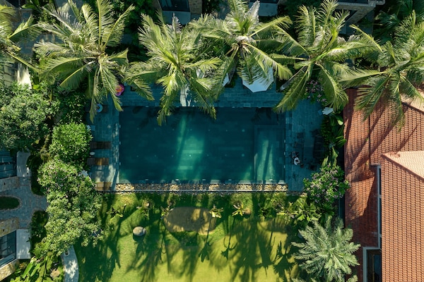 Una piscina al aire libre, sombrillas, sillones reclinables de piscina