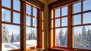 A room with large windows offering a view of a snowy mountain landscape.