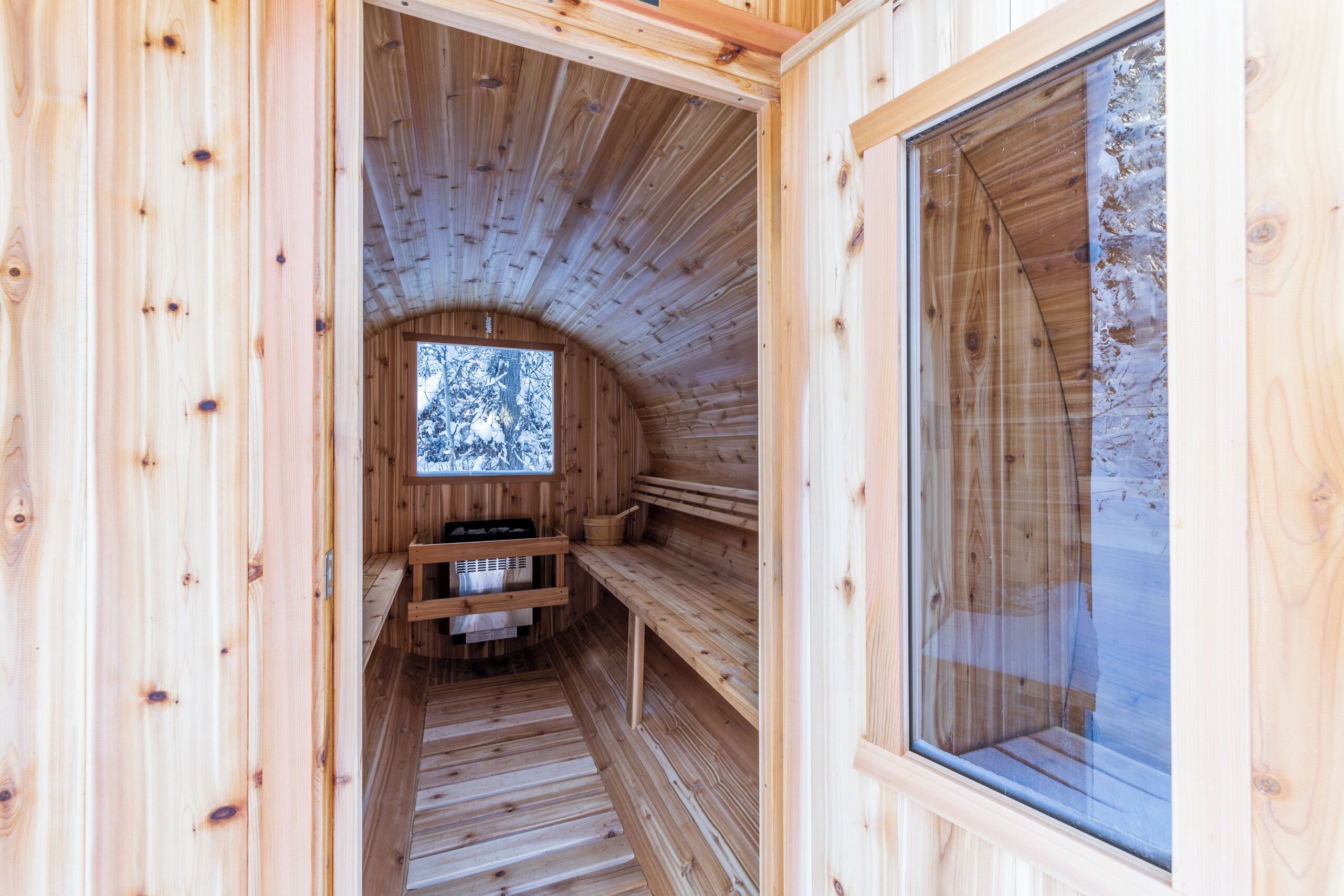 A wooden sauna with benches and a window.