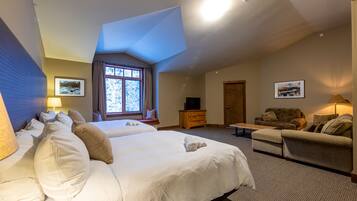 A spacious bedroom with a large bed, a sofa, and a TV.