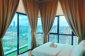 A hotel room with a large window offering a cityscape view. - Reizz Residence by Plush (Kuala Lumpur)