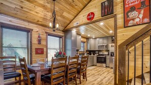 Un interior de madera con comedor, cocina y una escalera.