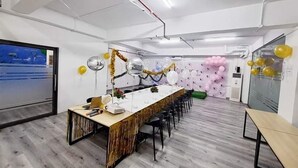 Una sala de conferencias moderna con una larga mesa, sillas y globos.