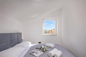 A bedroom with a bed, a window, and a view of a building. - Pool House Beba Tribalj Lake, Tribalj, Croatia (Tribalj)