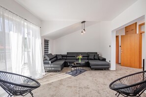 A modern living room with a sectional sofa, two black chairs, a coffee table, and a vase with flowers. - Pool House Beba Tribalj Lake, Tribalj, Croatia (Tribalj)