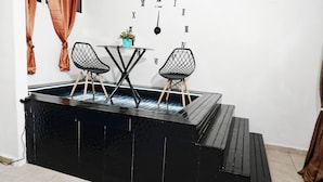 A modern kitchen with a black countertop, two black chairs, and a clock on the wall. - 1 Deluxe Lifestyle (Sosúa)