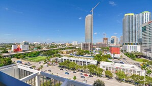 Une vue urbaine avec un grand immeuble de bureaux en construction, une pharmacie CVS et un mélange de bâtiments commerciaux et résidentiels.