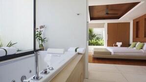A modern bathroom with a large bathtub, a mirror, and a potted plant. - Splash 4 Bed :Contemporary Tropical Five Star Villa (Koh Samui)