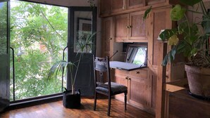 Une cuisine compacte avec des meubles en bois, une table à manger et une grande fenêtre donnant sur un paysage verdoyant.