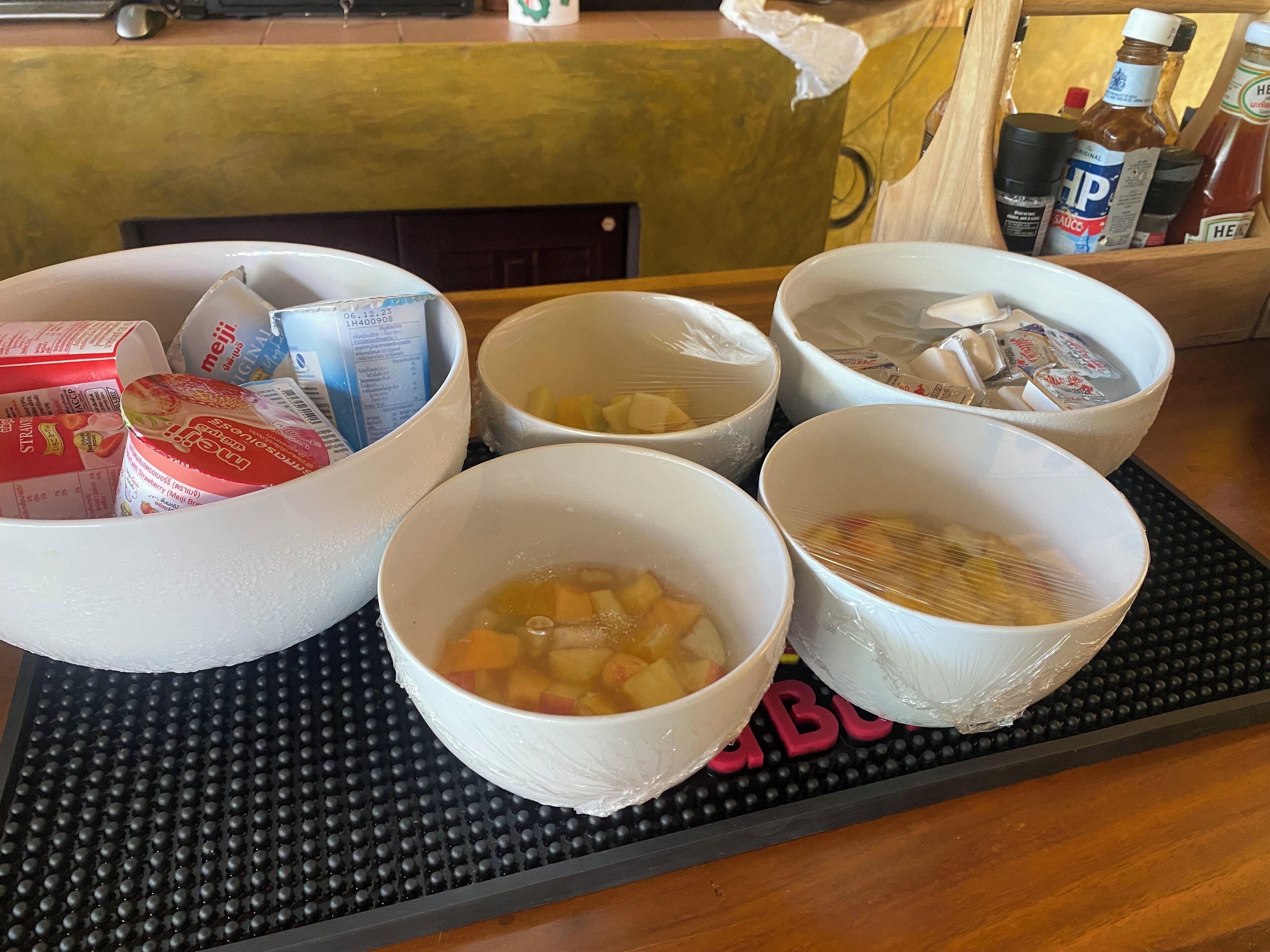 A table with bowls containing various food items and condiments.