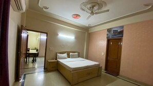 Un dormitorio con cama, mesita de noche y ventilador de techo.