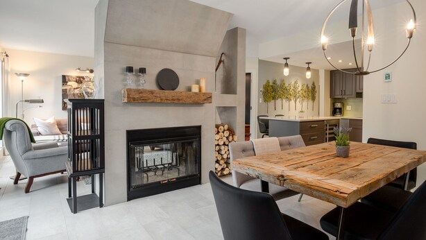 Un salon moderne doté d’une cheminée, d’un coin repas et d’une cuisine.