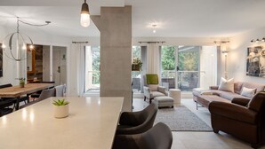 Un vaste espace de vie comprenant une grande table à manger, des sièges confortables et une vue sur l’extérieur.