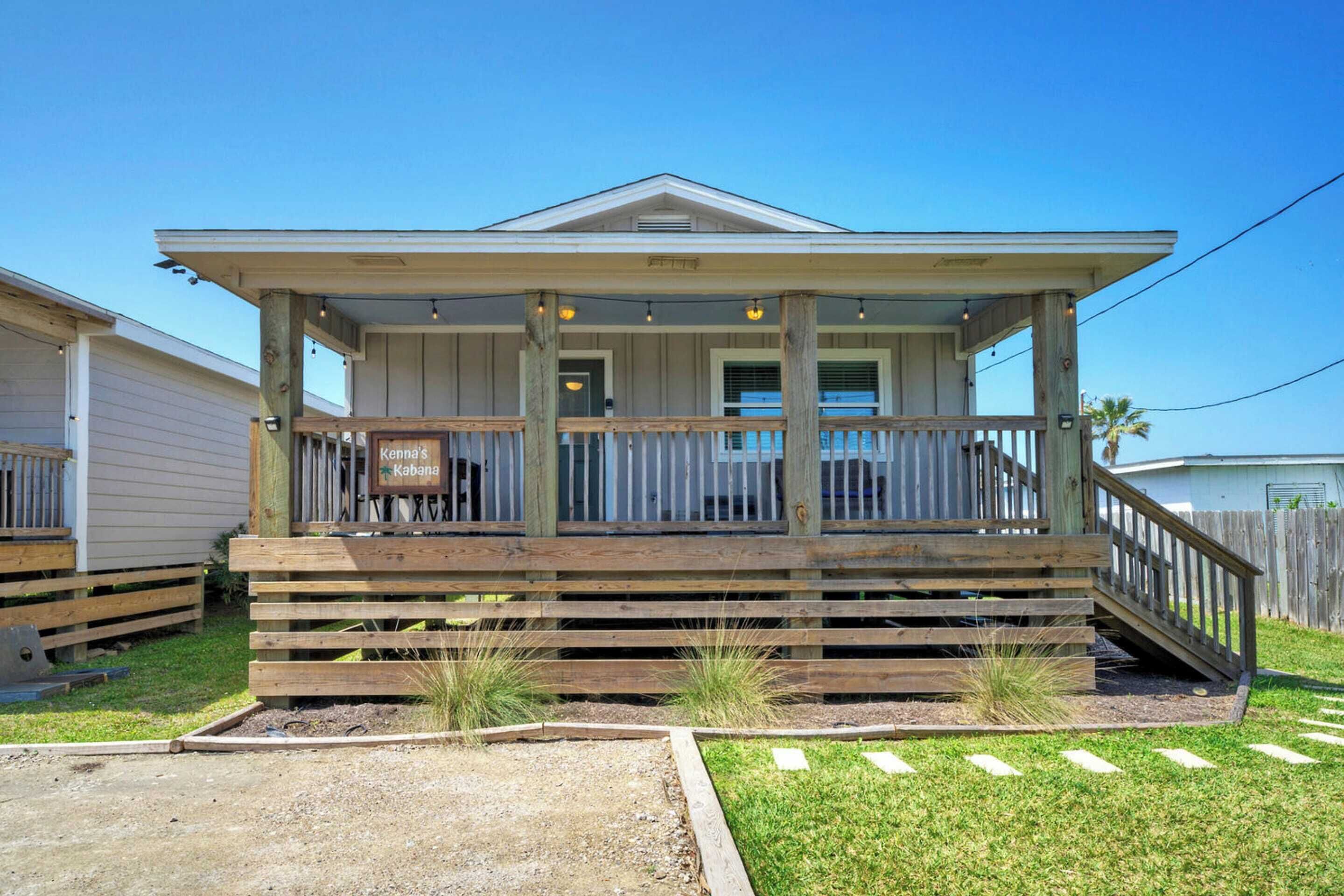 A two-story wooden house with a covered porch and a small front yard.