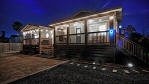 A two-story house with a porch, a staircase, and a driveway. - Kenna's Kabana by Avantstay Walk to Beach (Port Aransas)