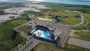 An aerial view of a resort with a swimming pool, tennis courts, and a baseball field. - Kenna's Kabana by Avantstay Walk to Beach (Port Aransas)