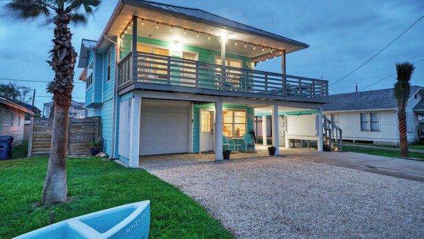 A two-story house with a balcony, a covered porch, and a garage. - Port A Hideaway by Avantstay Private Pool (Port Aransas)