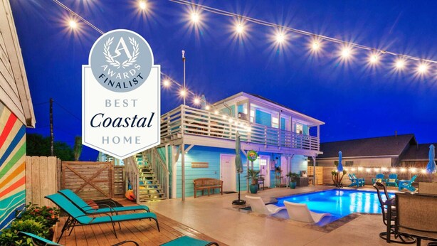 Una vivienda costera con piscina, sillas de descanso y luces colgantes.
