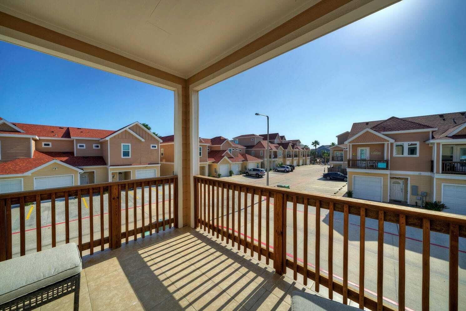 A balcony with a view of a residential street.