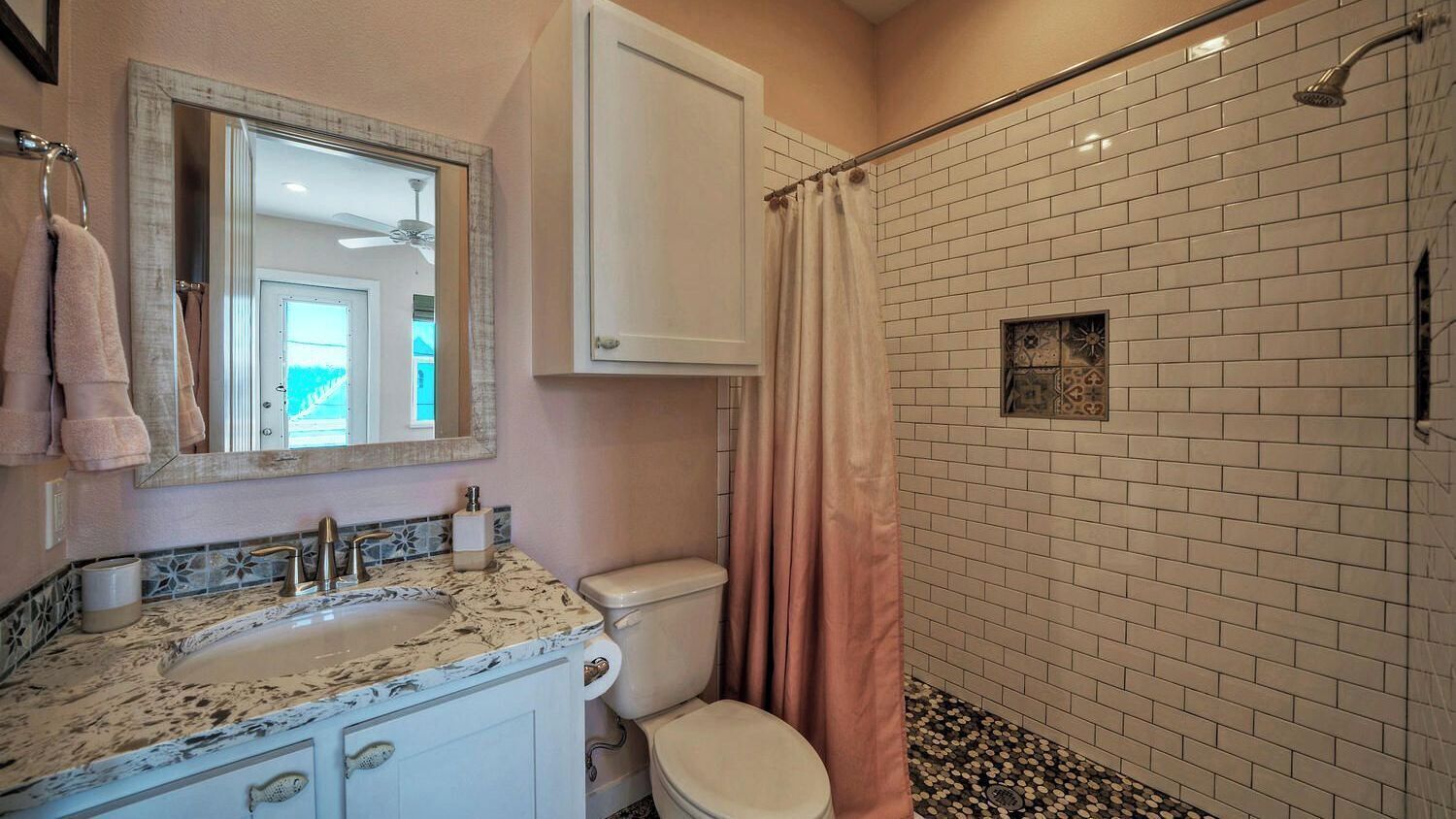 Ein Badezimmer mit Waschbecken, Toilette, Dusche und Spiegel.