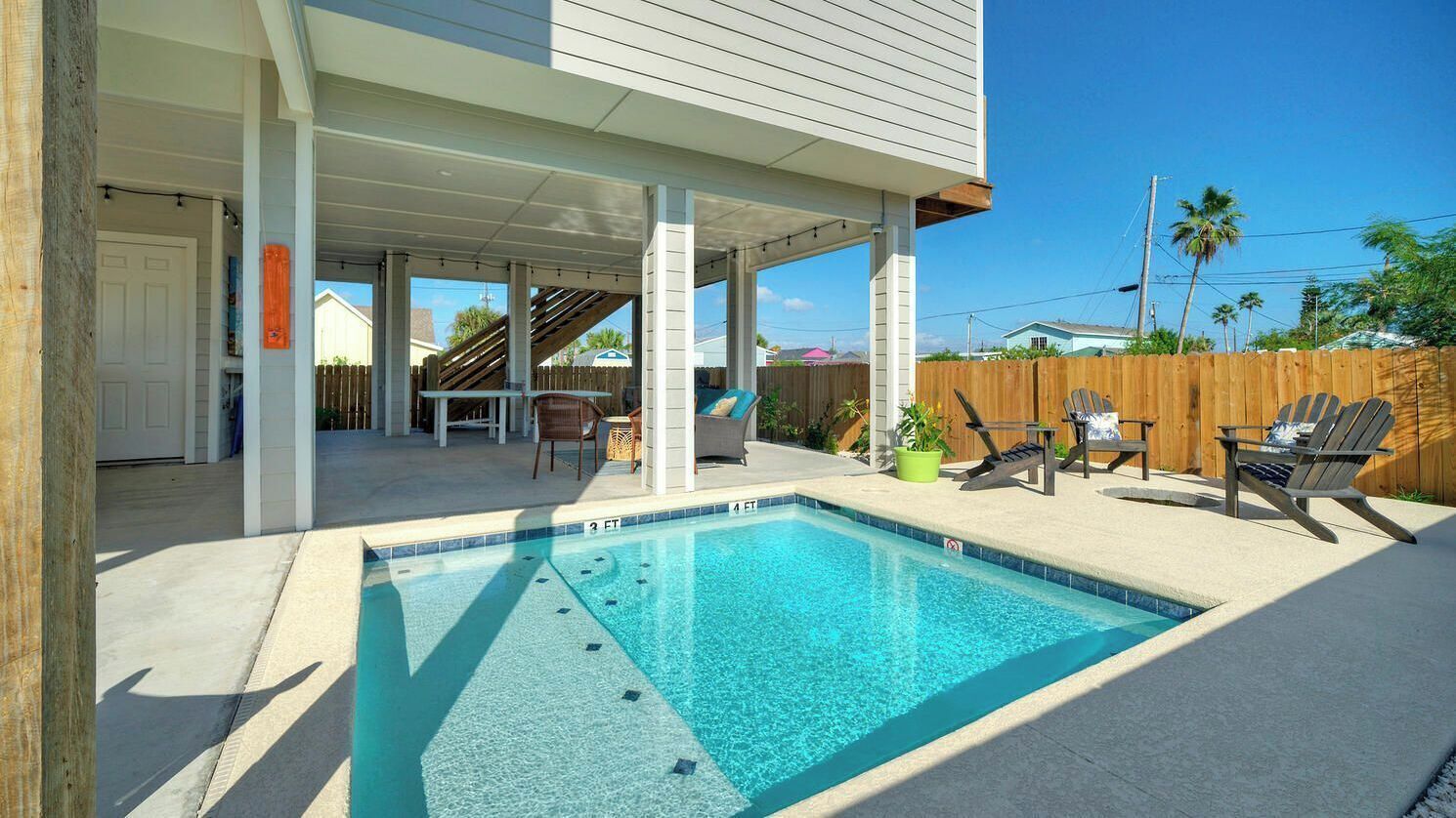 Una piscina coperta all'aperto con lettini e una zona solarium.