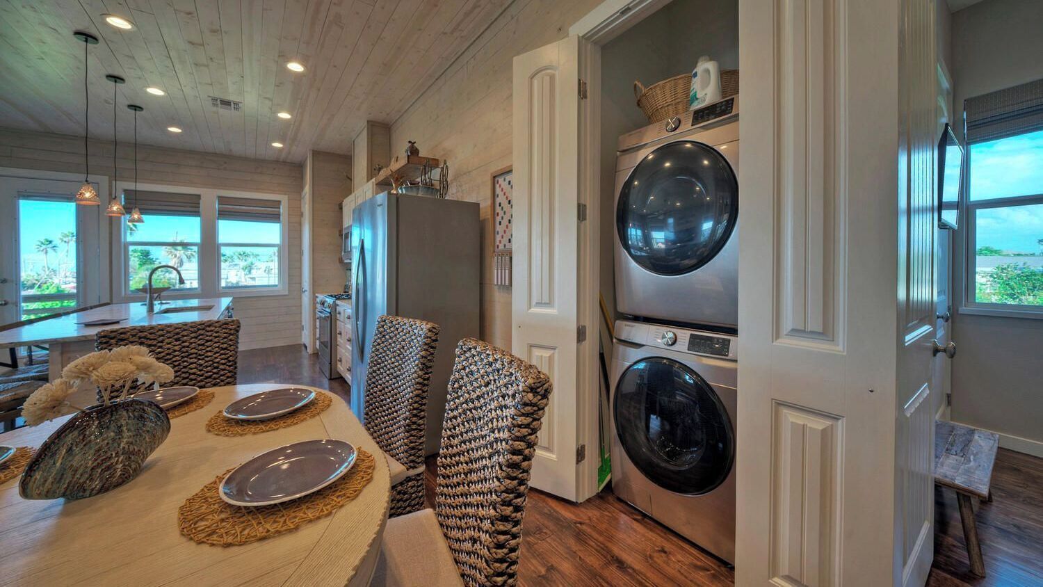 A modern kitchen with a dining area, built-in appliances, and a view of the outdoors.