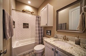 Un baño con bañera, inodoro y lavamanos.
