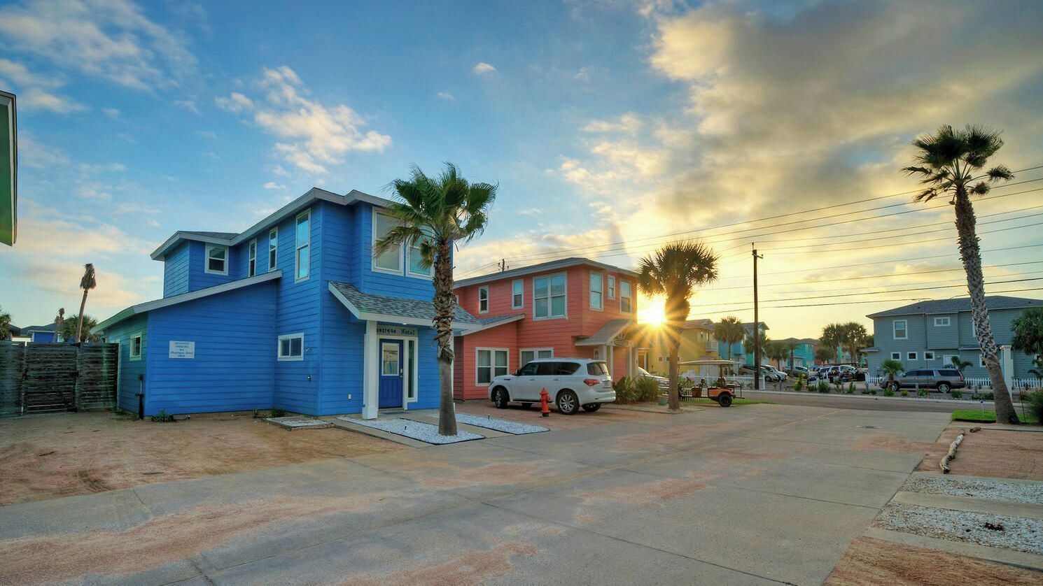 Zona residencial con casas, un automóvil blanco y un carrito de golf.