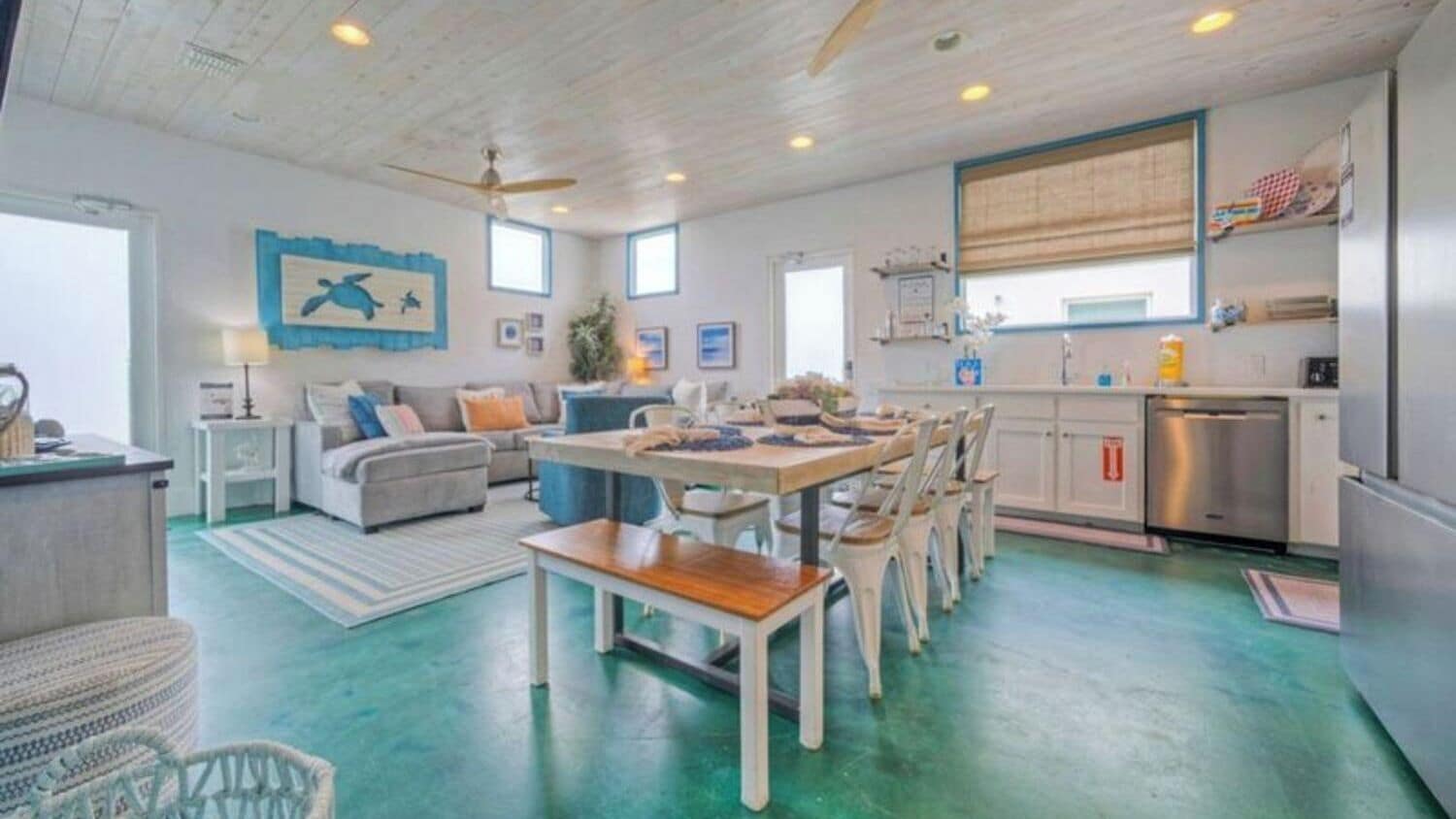 A spacious living area with a dining table, seating, and a kitchen area.