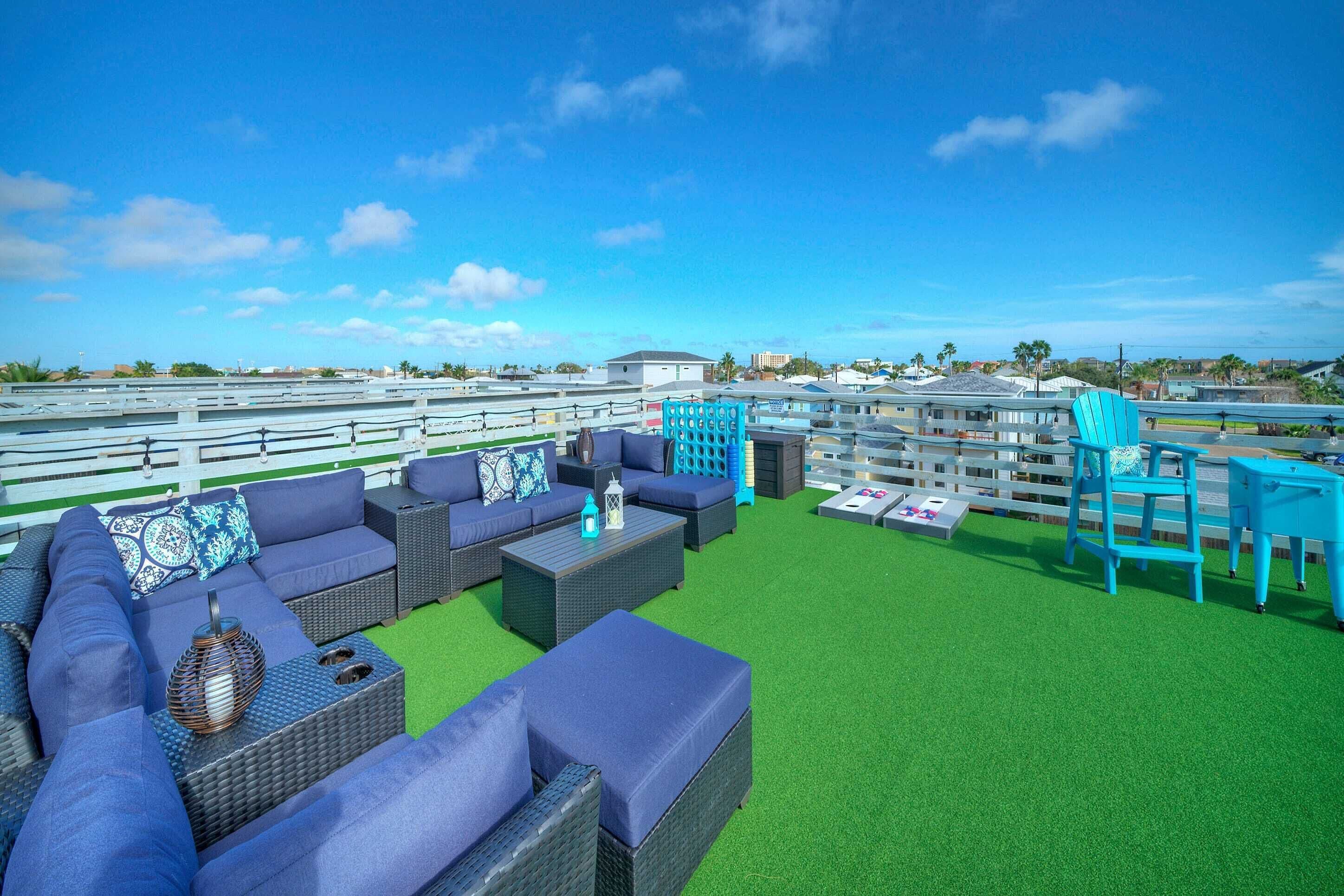 A rooftop lounge area with outdoor furniture, a view of the city, and a railing.
