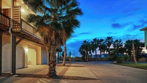 A residential property with a covered porch, a garage, and a well-maintained lawn. - Pool, Walk to Old Town + Eateries, Nightlife, Shopping Rock N Reelby Avantstay (Port Aransas)