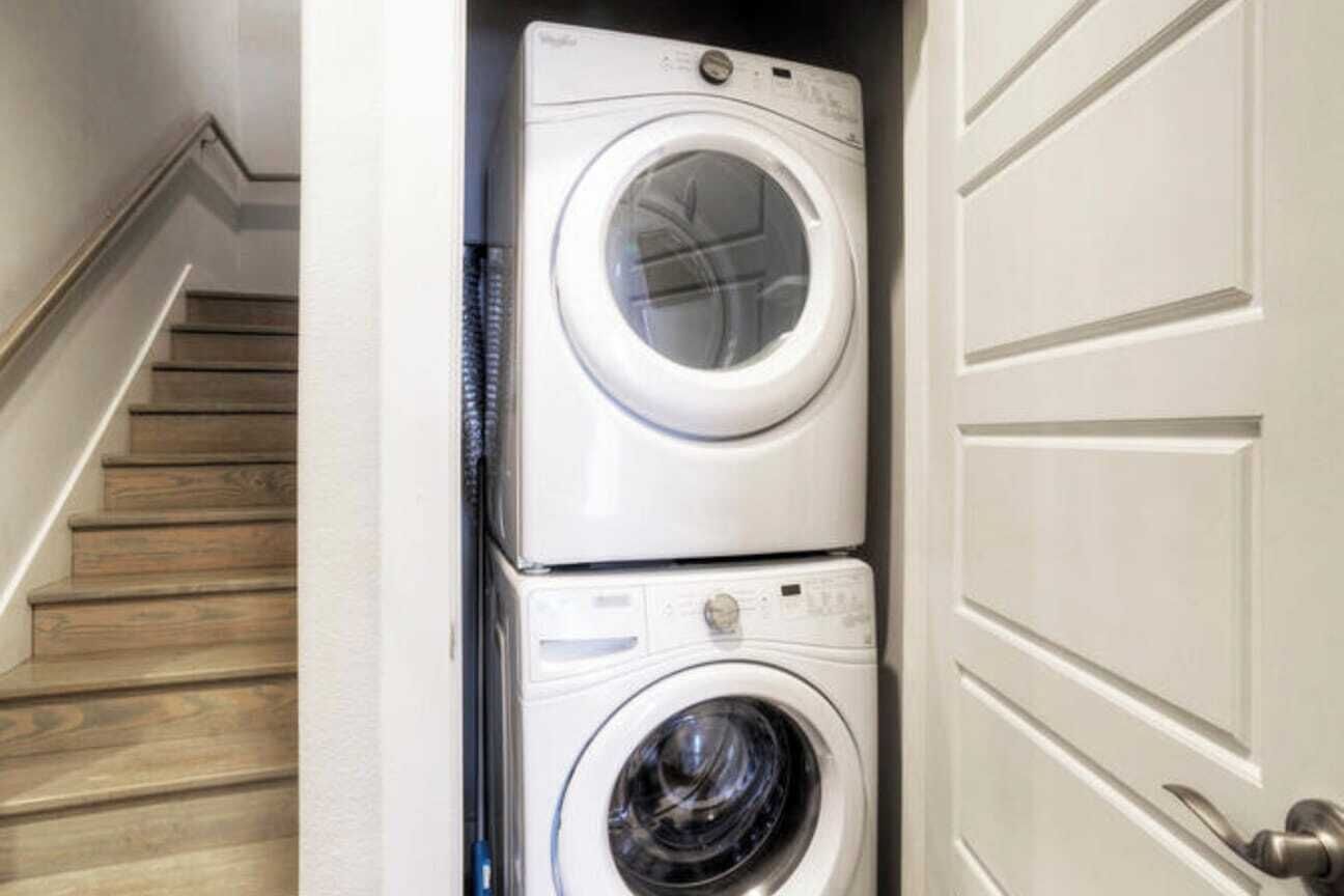 A laundry room with two stacked washing machines.