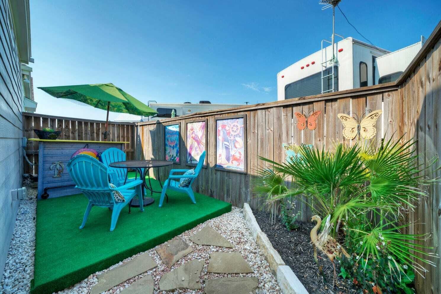 A backyard with a patio area, a wooden fence, and a small garden.