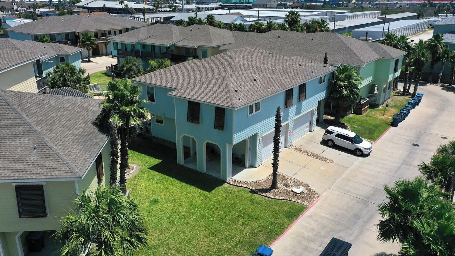 A residential area with multiple two-story houses, each with a garage and a front yard.