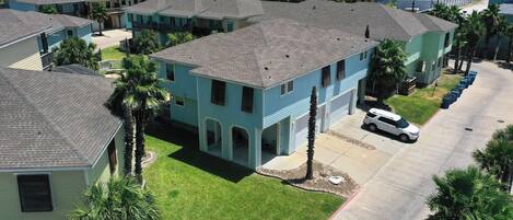 A residential area with multiple two-story houses, each with a garage and a front yard.