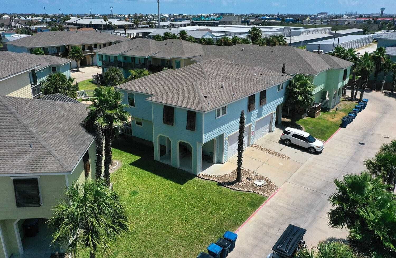 A residential area with multiple two-story houses, each with a garage and a small front yard.