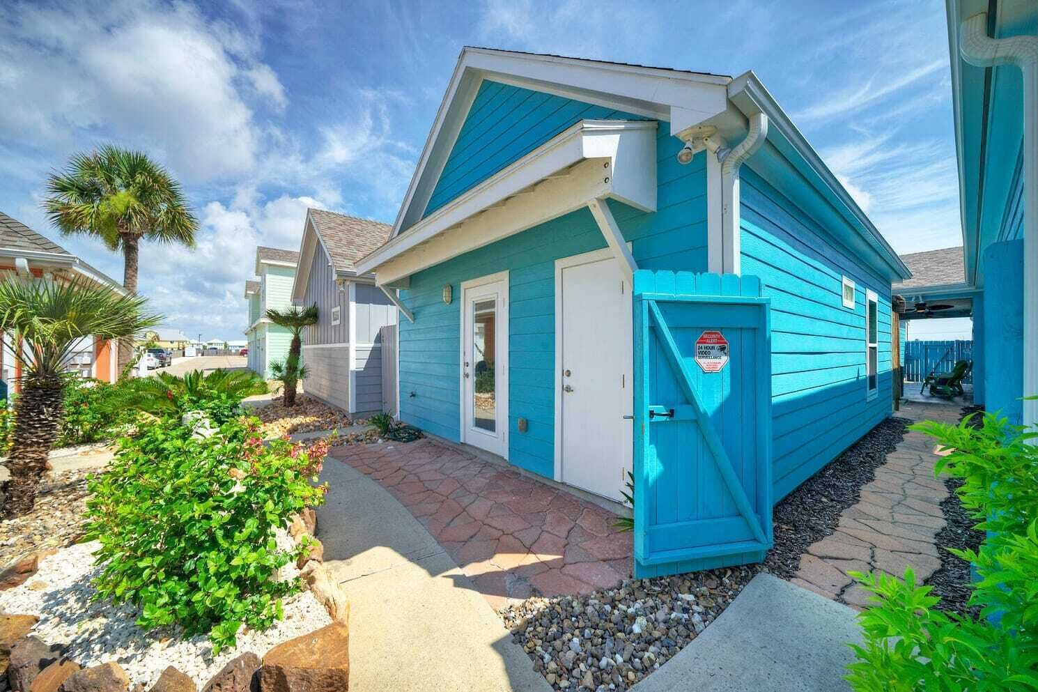 A blue house with a white door and a small porch area.