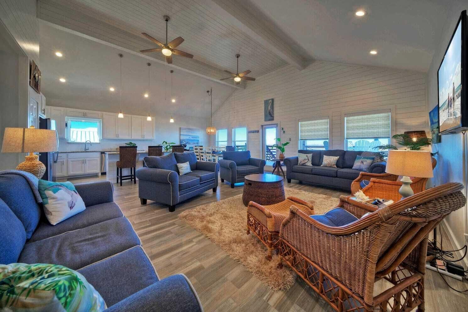 A spacious living area with multiple sofas, a dining area, and a kitchen.