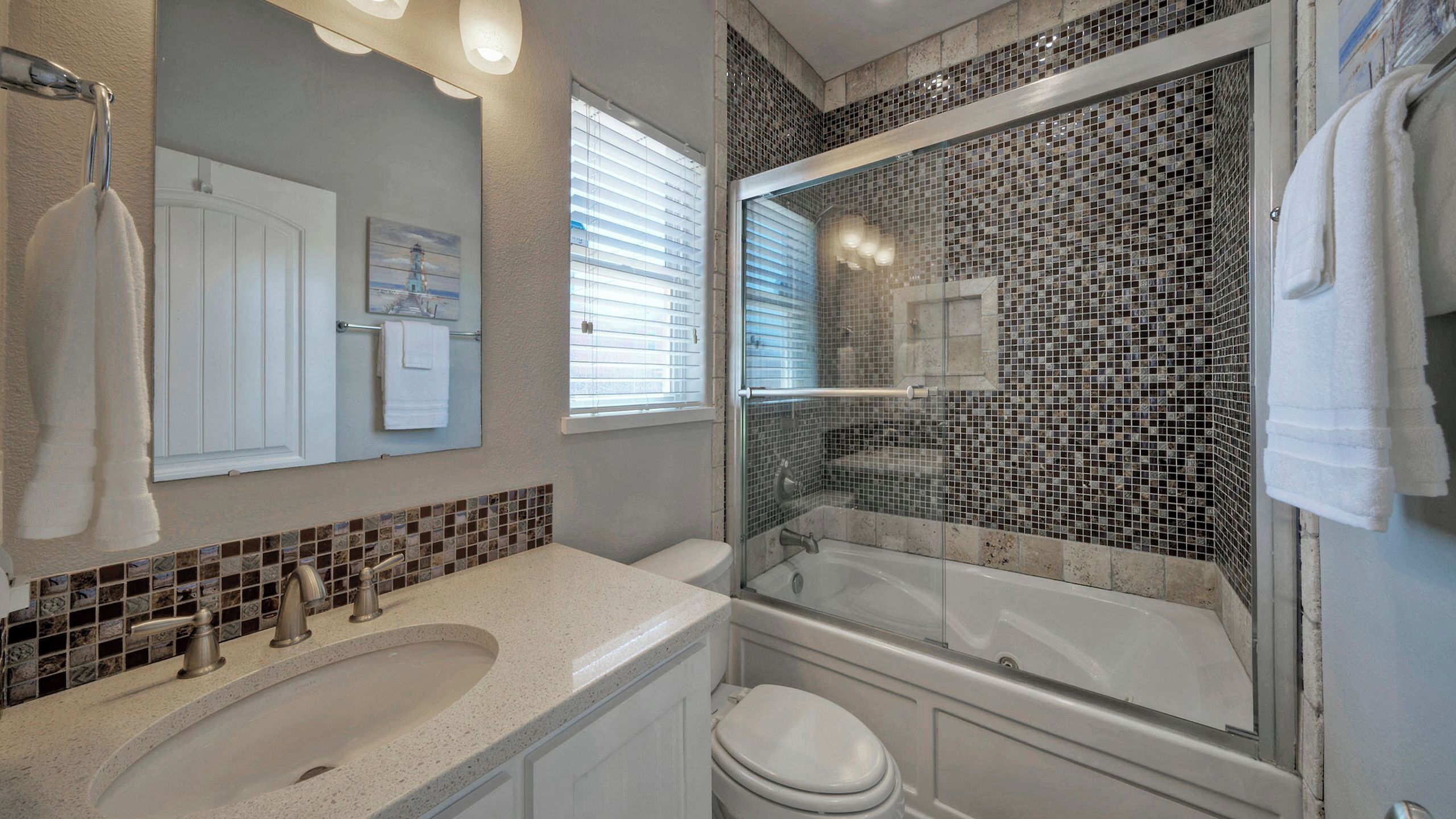A bathroom with a bathtub, a shower, a toilet, a sink, and a mirror.