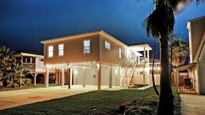 A two-story house with a covered garage and a staircase leading to the upper level. - Priv Pool & Yard w/ Putting Green! Newly Remodeled Always Sunny by Avantstay (Port Aransas)