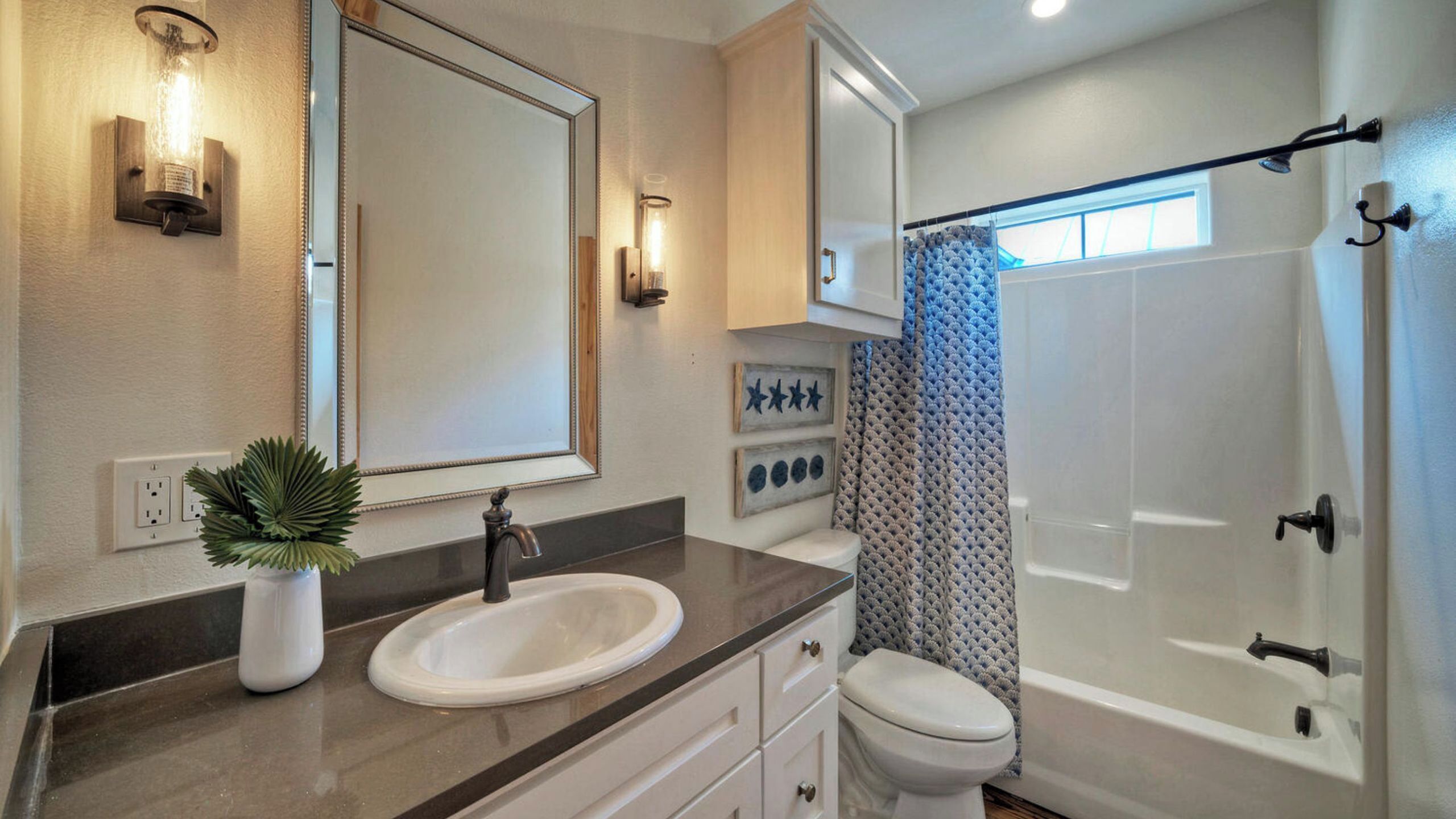 A bathroom with a sink, mirror, and toilet.