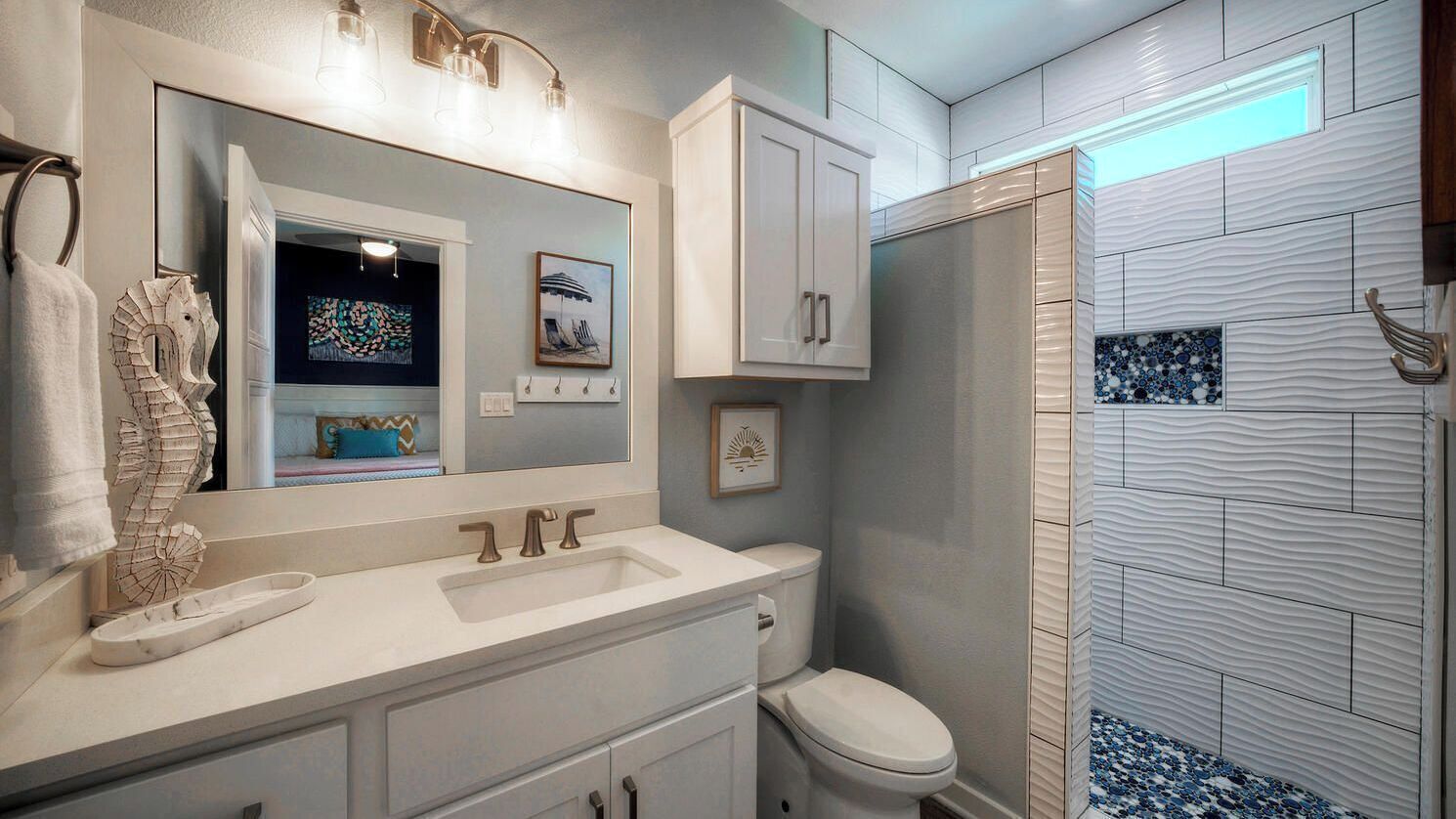 A bathroom with a sink, toilet, and shower area.