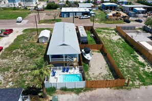 Overlooking a serene pool, this two-story house offers a balcony and a fenced yard with a boat dock.