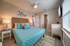 Cozy retreat with a large bed, nightstand, and wall-mounted TV.