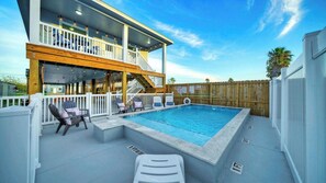 A two-story building with a swimming pool, outdoor seating, and a wooden deck. - Priv Pool, Swing Bar, Ping-pong, Walk to Town Once Upon A Tide by Avantstay (Port Aransas)