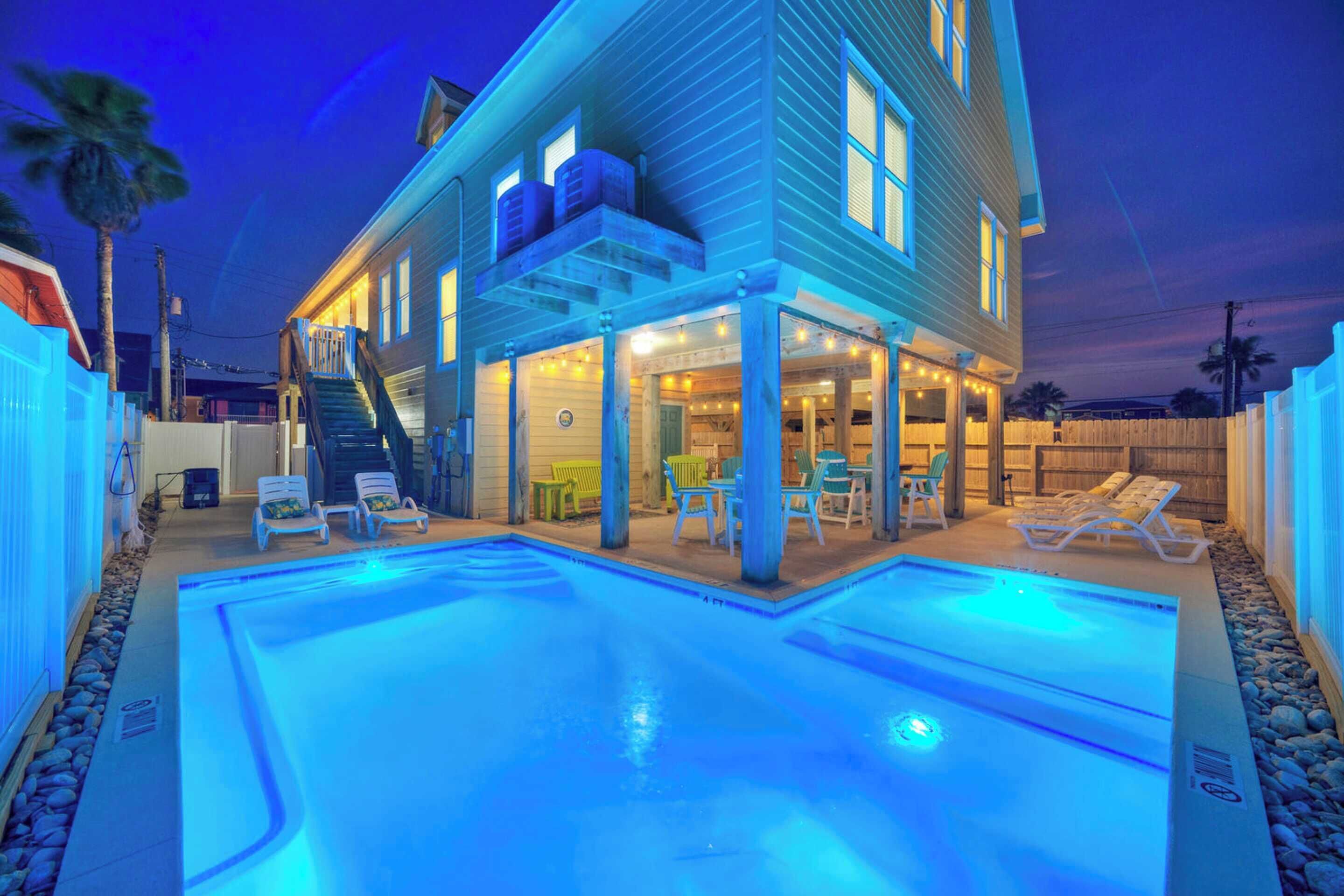 A two-story house with a swimming pool, outdoor seating, and a covered patio area.