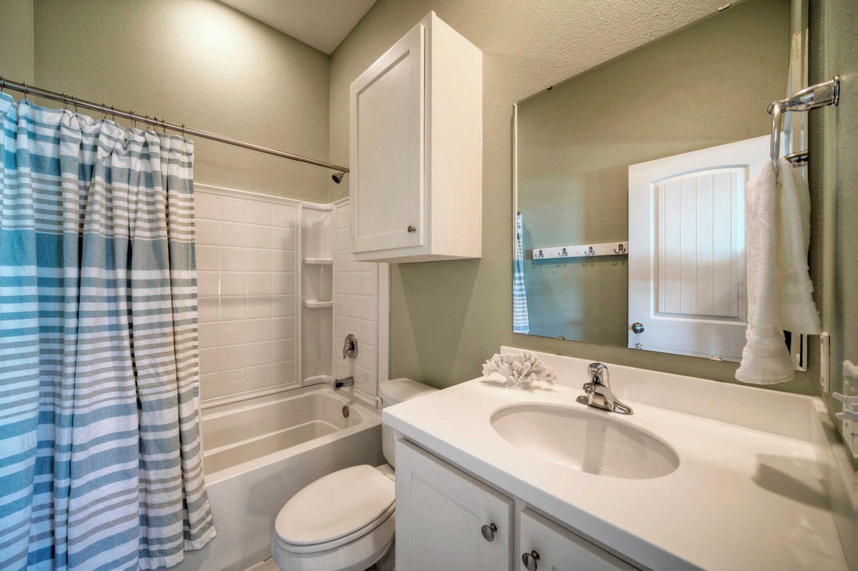 A bathroom with a bathtub, toilet, and sink.